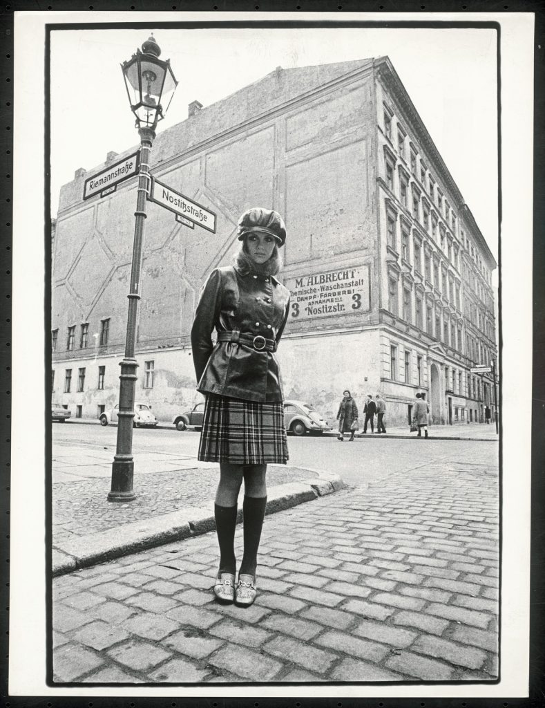 Rico Puhlmann, Nicole im Schotten-Kilt und Kniestrümpfen, darüber lange enggegürteter Lederjacke von Hobbydress, Berlin-Kreuzberg, 1968, Silbergelatinepapier, 39,9 x 30,4 cm© Rico Puhlmann Archive (veröffentlicht in „Total Look“, petra, Nr. 3, 1968)